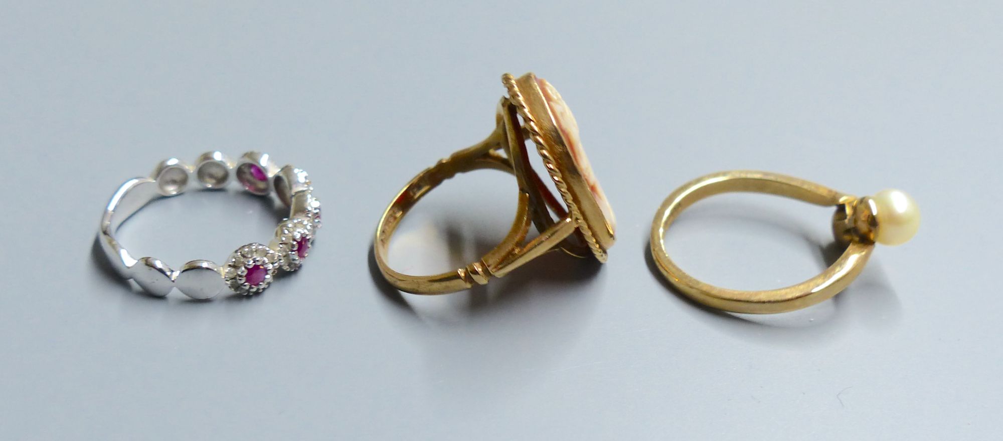 A white gold, ruby and diamond chip five cluster ring, a cameo ring and a pearl set ring